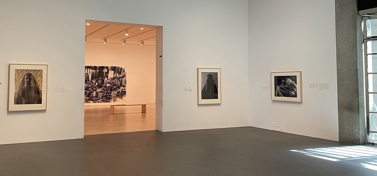 Three large framed photographs of veiled men installed at the National Gallery of Canada